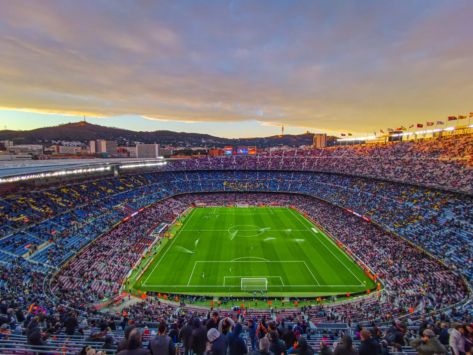 Pełne trybuny Camp Nou w Barcelonie podczas meczu, o zachodzie słońca